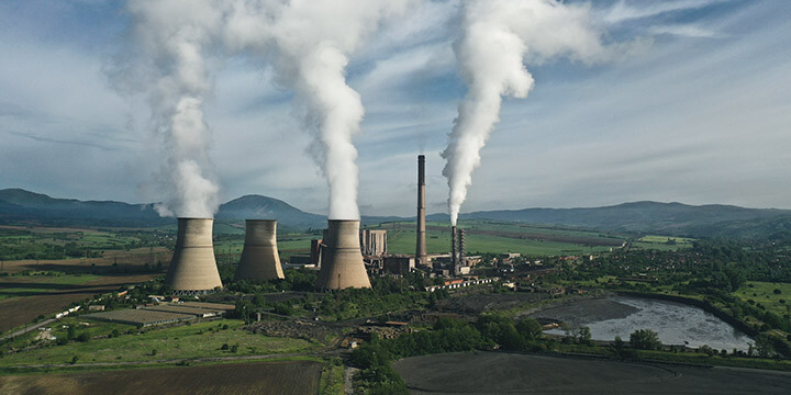 Usinas termelétricas em operação, emitindo vapor, representando geração de energia não renovável.